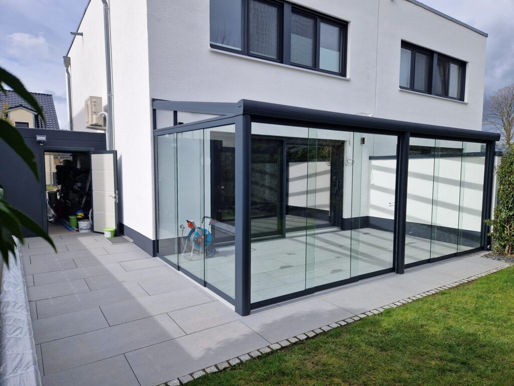 Glasschiebewand aus Aluminium über Eck an einem Wohnhaus
