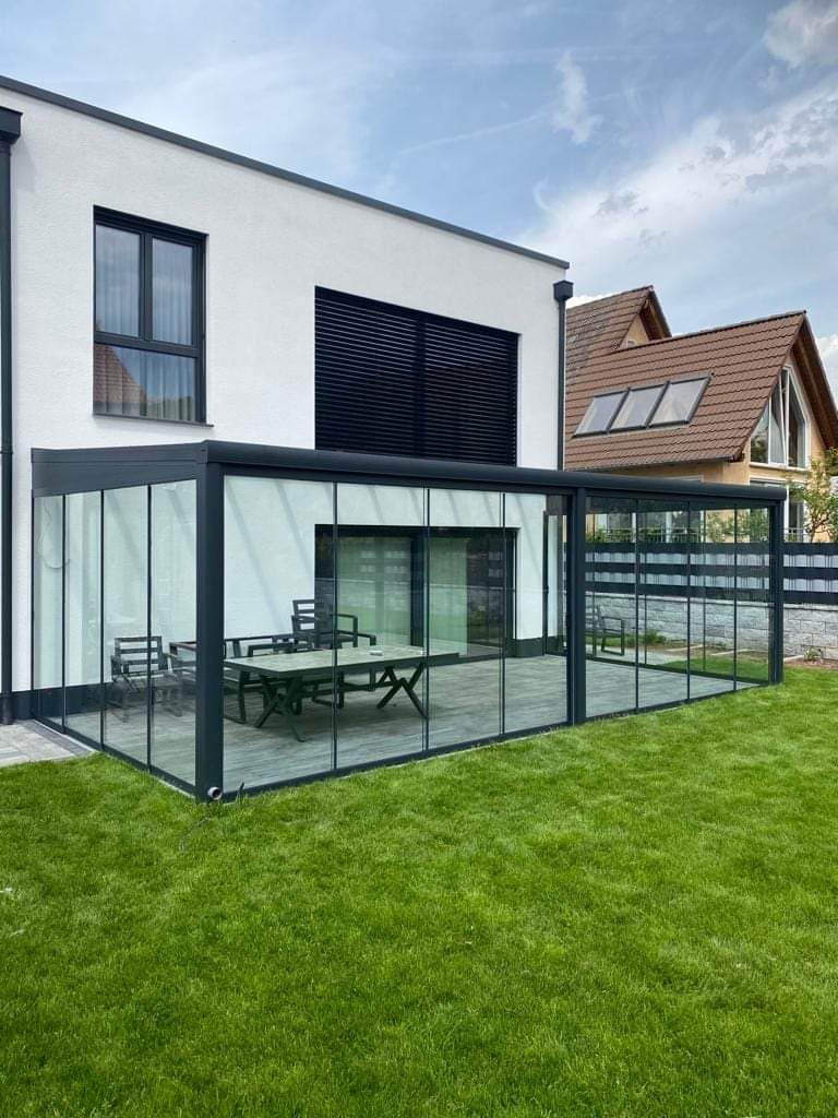 Wintergarten aus Aluminium mit bodentiefer Verglasung am Rasen in Paderborn